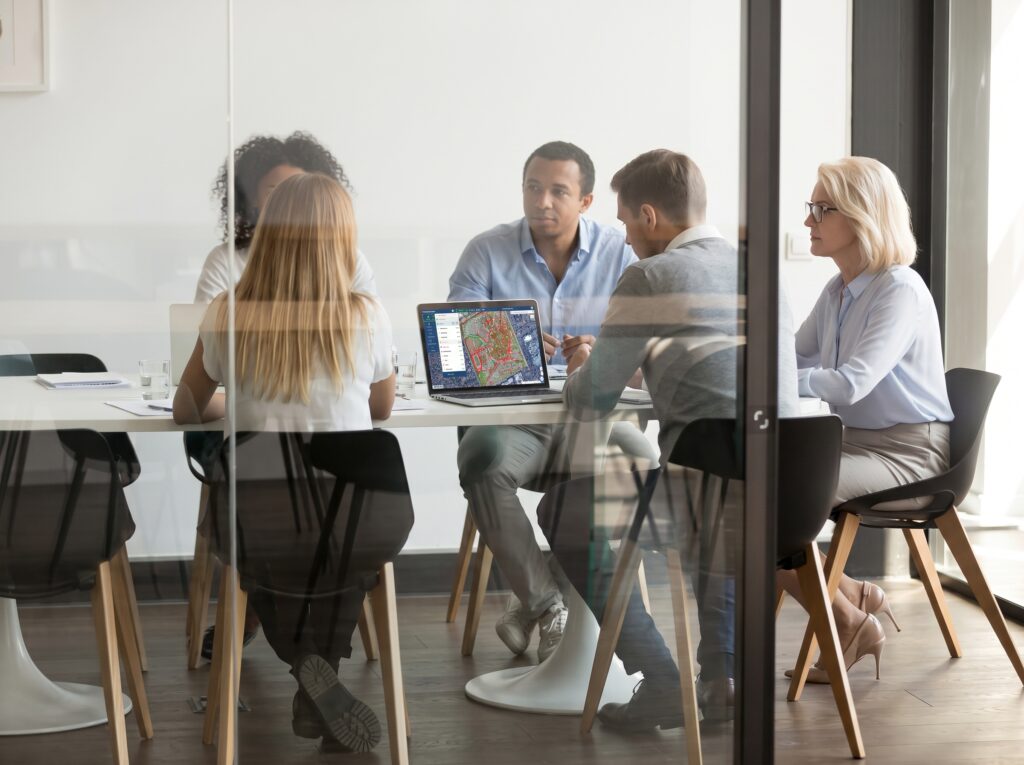 Team from several departments meeting around a laptop showing an InfraMappa facility map