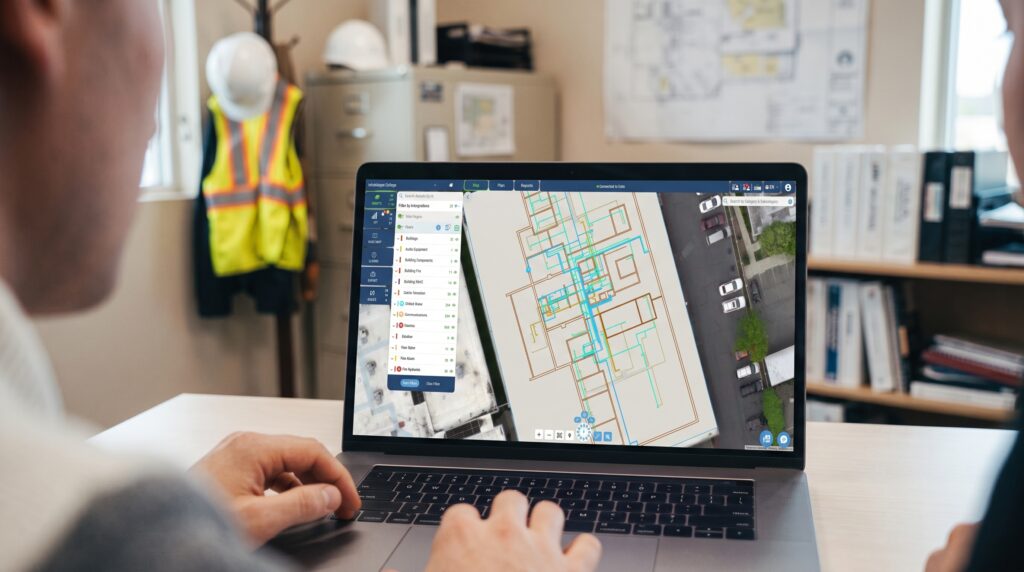 Facilities team member reviewing a building's interior utility map in InfraMappa on a laptop